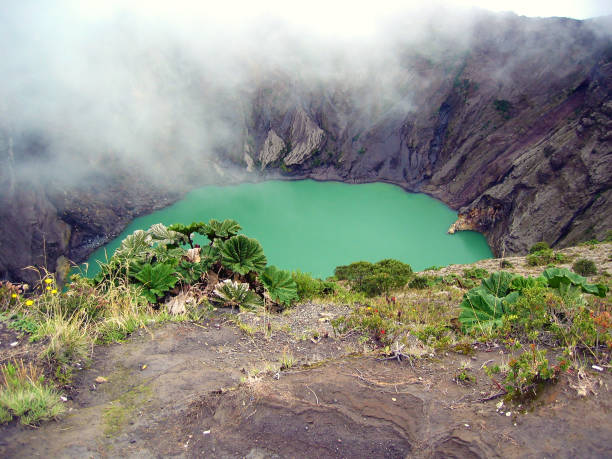 Irazu crater Main crater of Irazu Volcano with green lake and mist, Costa Rica, Central America irazu stock pictures, royalty-free photos & images