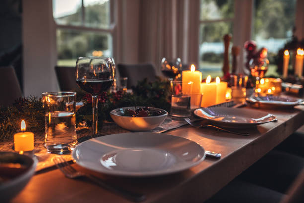 Decorated dining tablet on christmas eve. Close up shot of christmas festive table with no people. Dining table with plates, wine glasses and candles. dining table stock pictures, royalty-free photos & images