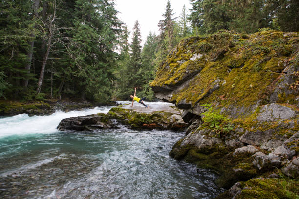 istock Young woman doing yoga by the raging river 863577998