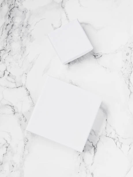 istock White square packages or boxes for jewelry on white marble background. Flat lay. Top view. Copy space. 863583178