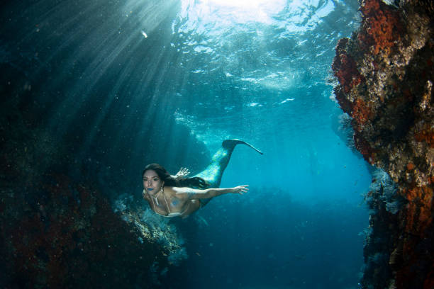 istock Mermaid swimming underwater in the deep blue sea 863583358
