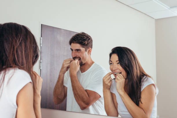 istock Couple using dental floss to clean their teeth 863586650