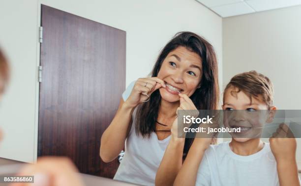 Mother And Son Cleaning Teeth With Dental Floss Stock Photo - Download Image Now - Dental Floss, Child, Teeth
