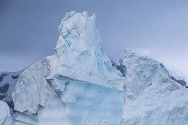 énorme iceberg fond sombres nuages - glacier antarctica crevasse ice photos et images de collection