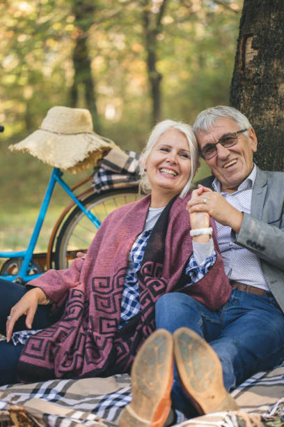istock Romantic senior couple seated on the grass and relaxing while picnic. 863593520