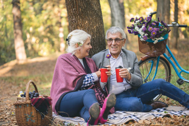 istock Senior couple sitting in the forest while relaxing and drinking a cup of coffee 863604432