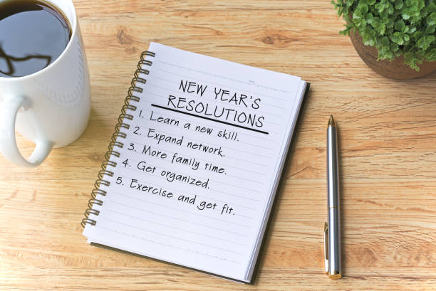 new year's resolutions written on notepad with pen, coffee and plant on top of wooden table. - condition optimal text healthy lifestyle imagens e fotografias de stock