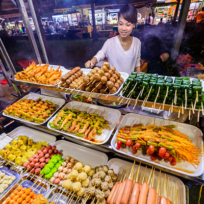 Vietnamese man selling street food on night market, Mekong River Delta, South Vietnam