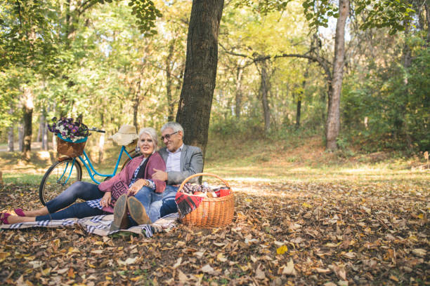 istock Romantic senior couple seated on the grass and relaxing while picnic. 863620580