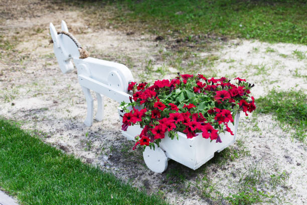 Surreal countryside illustration with a cup full of flowers in a green field – 3D render