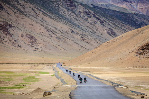 Road through Changthang plateau Motorcyclists on the road through Changthang plateau in Ladakh region of Kashmir, India ladakh region photos stock pictures, royalty-free photos & images
