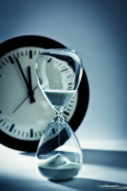 istock Deadline and Out of Time: Sand Timer Hourglass and Clock at Midnight 863624350