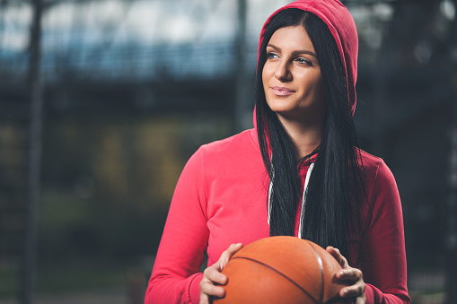 Young female basketball player training outdoors on a local court