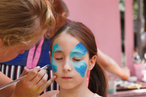 istock Female child face painting, making butterfly process 863655536