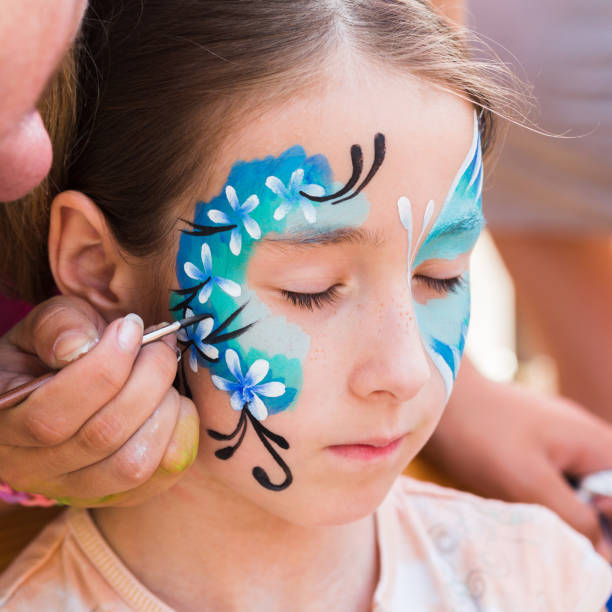 istock Female child face painting, making butterfly process 863655664