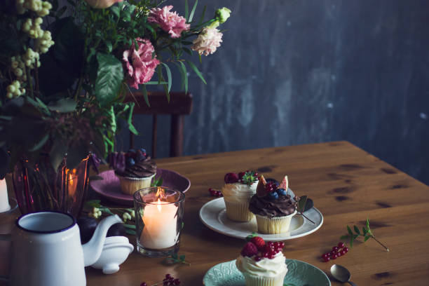 istock The beautiful festive table with rustic bouquet, cupcakes and candles. Copy space 863656534