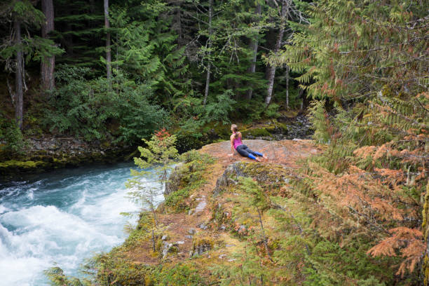 istock Women does some yoga on a rock by the river 863656796