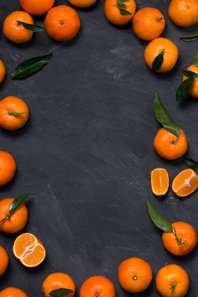 istock Group of fresh tangerines with leaves on a black background 863661638