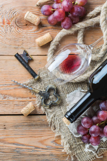 istock Bottle, corkscrew, glass of red wine, grapes on a table 863674928