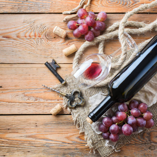 istock Bottle, corkscrew, glass of red wine, grapes on a table 863681236
