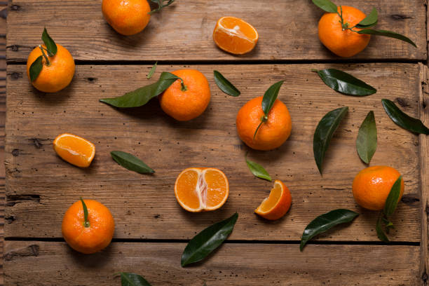 istock Fresh clementines with leaves on wooden table 863682204