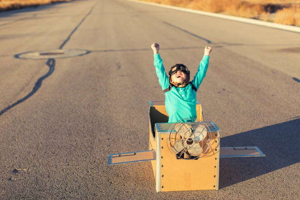 istock Young Boy Pilot Flies Cardboard Airplane 863689166