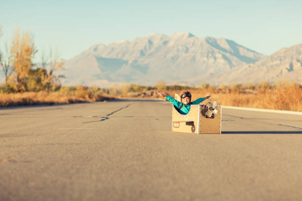 istock Young Boy Pilot Flies Cardboard Airplane 863689170