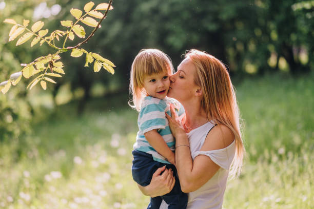 istock mom is kissing her son in nature 863693116