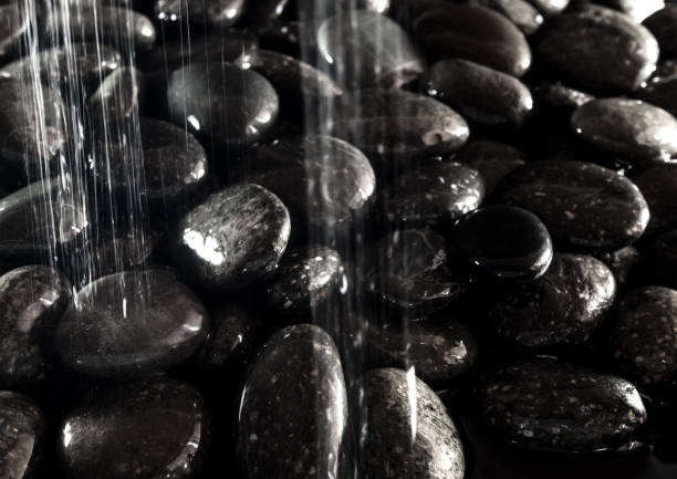 istock Round black stone on ground beside the waterfall 863693570