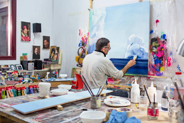 uomo d'affari artista maturo nel suo studio d'arte - uomo dipinge foto e immagini stock