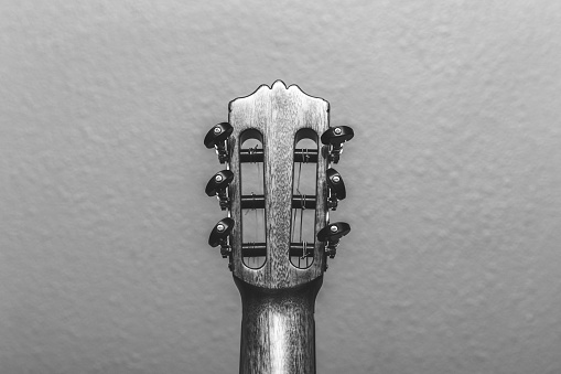 Headstock of an acoustic guitar seen from the back side in black and white.