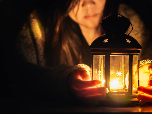 istock candle light and black lantern with soft focus background girl(25s to 35s) in the winter cloth see and pray in christmas night 863698708