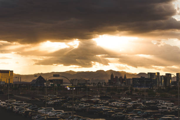 View of Las Vegas Skyline with mountains in the background and sun rays shining down through cloud formations.