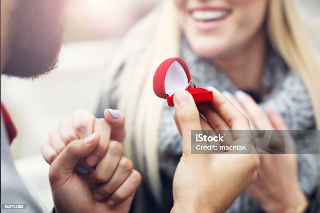 Adult man giving engagement ring to beautiful woman Picture of an adult man giving engagement ring to beautiful woman Winter Stock Photo