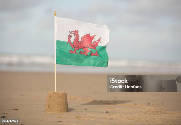 Welsh Flag Flying In A Sandcastle On A Beautiful Cymru Beach Stock Photo - Download Image Now