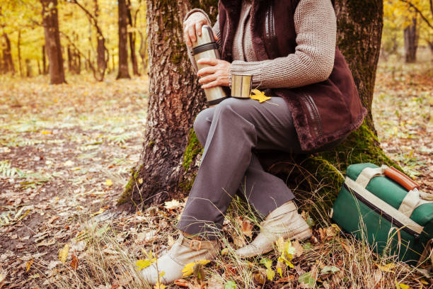 istock Traveller woman drinks tea in autumn forest 863717598