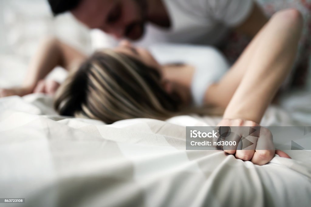 Young attractive couple having romantic time in bed Young attractive happy couple having romantic time in bed Sexual Issues Stock Photo
