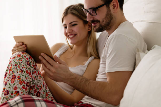 istock Young attractive couple using tablet in bedroom 863723454