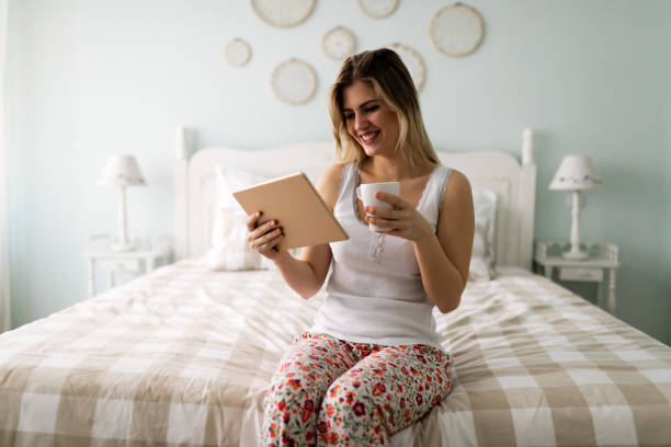 istock Beautiful woman using digital tablet in bed 863723754