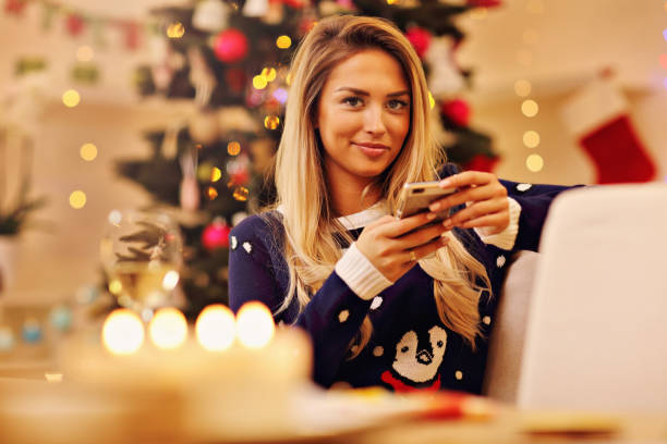 istock Young woman with smartphone during Christmas at home 863728566