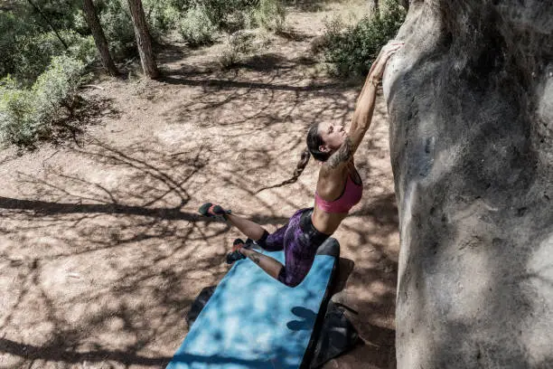 Woman practicing boulder rock climbing in Sant Joan de Vilatorrada Catalonia