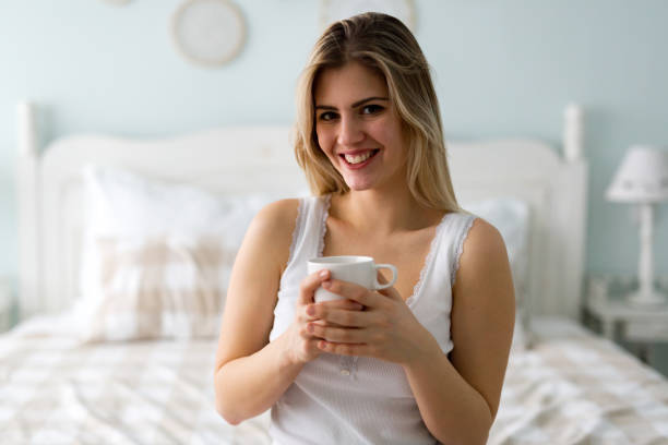 istock Young beautiful woman sitting on bed at home 863734132