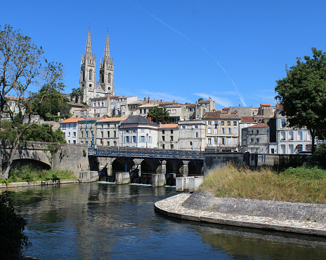 Niort, France, July 16 2017: A view of the historic town of Niort and St Andre's church, on the Sevre Niortaise River. Niort is large town in the Deux-Sèvres department in western France with a population of 60,000+.