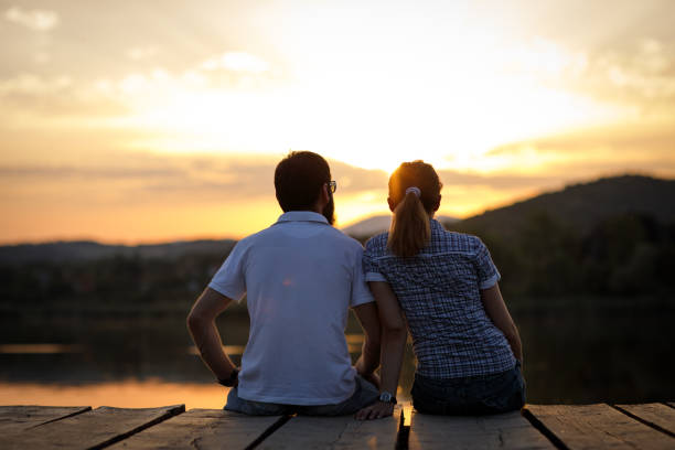 istock Couple enjoying sunset at lake pier 863734600