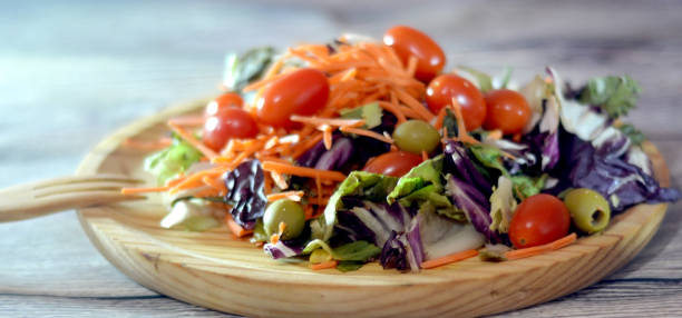istock Fresh salad on a wooden plate 863734696