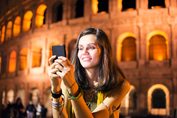 istock Smiling young woman using phone in Rome, Italy 863740292