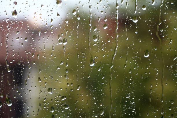 istock Rain drops on window glass with green in background 863746916