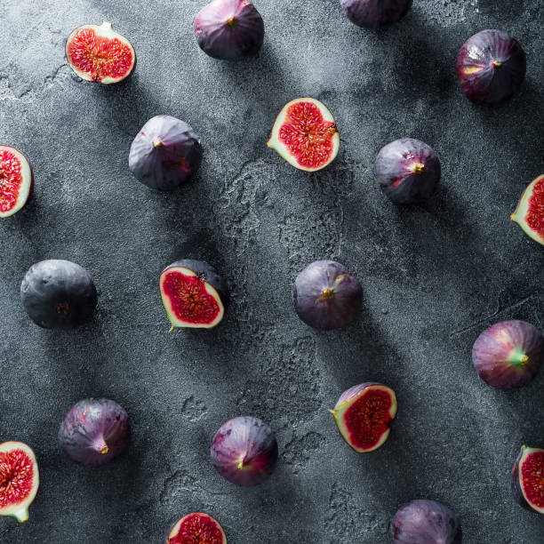 istock Black figs berries arrangement on dark background. Flat lay, Top view 863747242