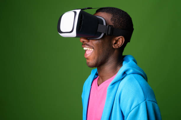 istock Studio shot of young African man using virtual reality headset against green background 863747290