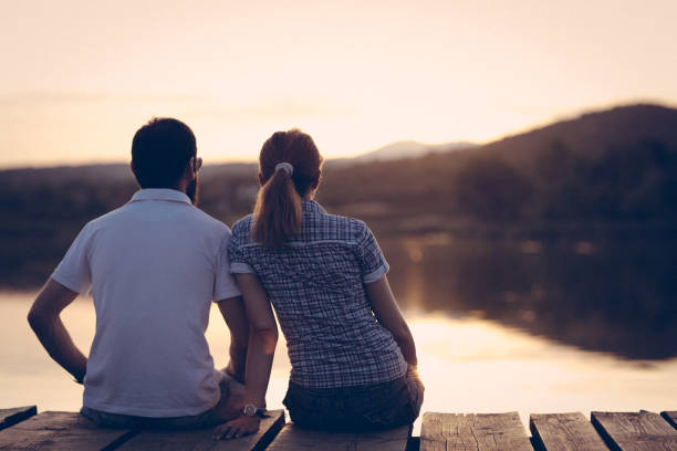 istock Couple enjoying sunset at lake pier 863749910